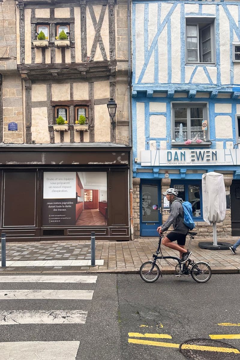 Cycliste devant des maisons à colombages dans le centre de Rennes