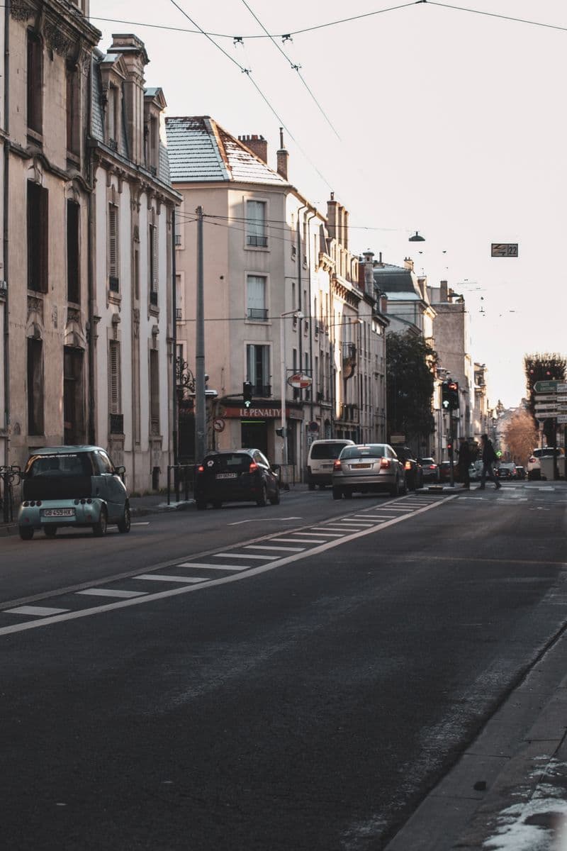 Rue du centre de Nancy avec voitures stationnées le long d'immeubles anciens
