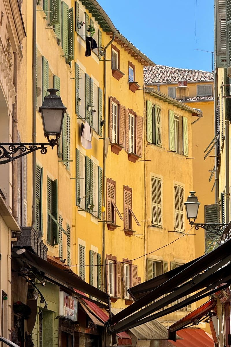 Ruelle étroite de Nice aux façades jaunes et volets verts