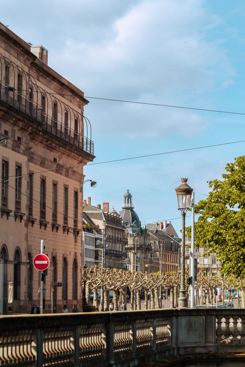 Rue du centre de Strasbourg avec immeubles en grès, panneau sens interdit et réverbère